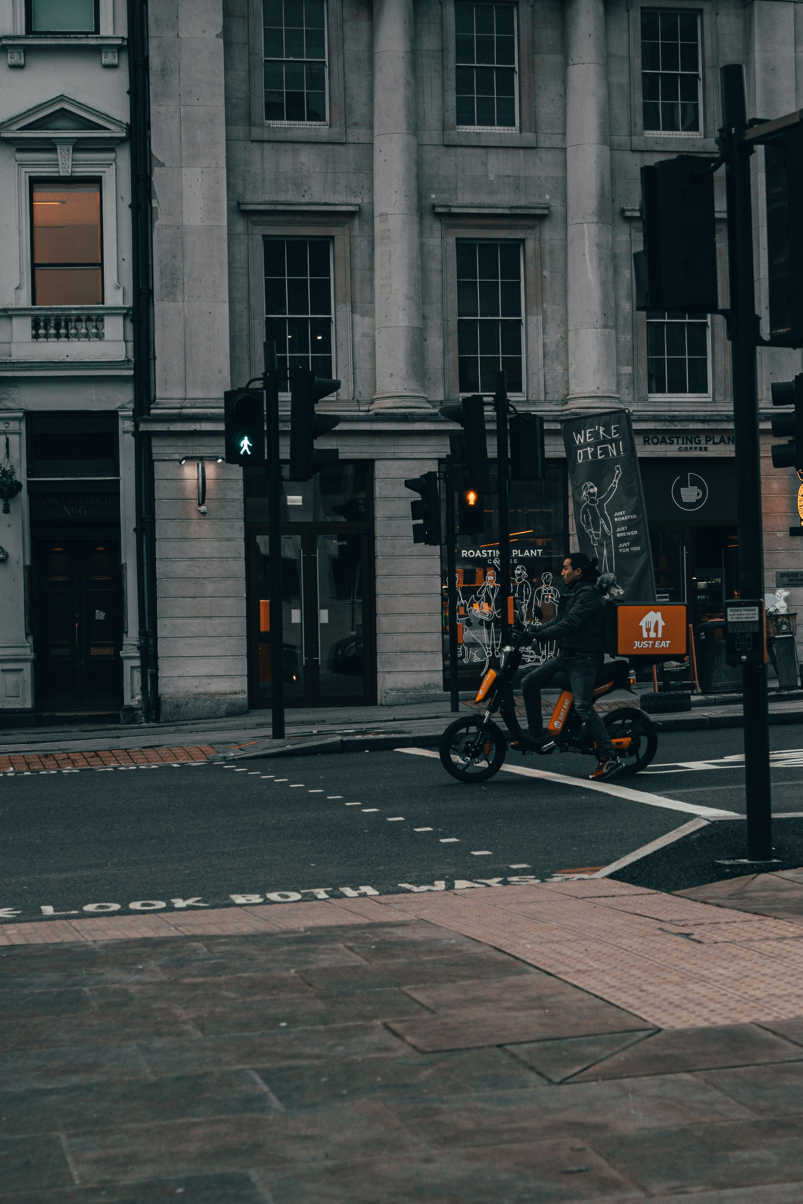 orange and black motorcycle parked beside black and gray building during daytime